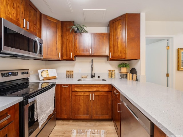 725 Kapiolani Blvd Unit 1105, Honolulu, HI 96813 - kitchen with stainless steel appliances, a sink, light wood-style flooring, and brown cabinetry