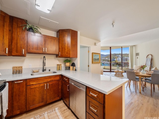 725 Kapiolani Blvd Unit 1105, Honolulu, HI 96813 - kitchen with stainless steel dishwasher, a sink, light wood finished floors, light countertops, and a peninsula