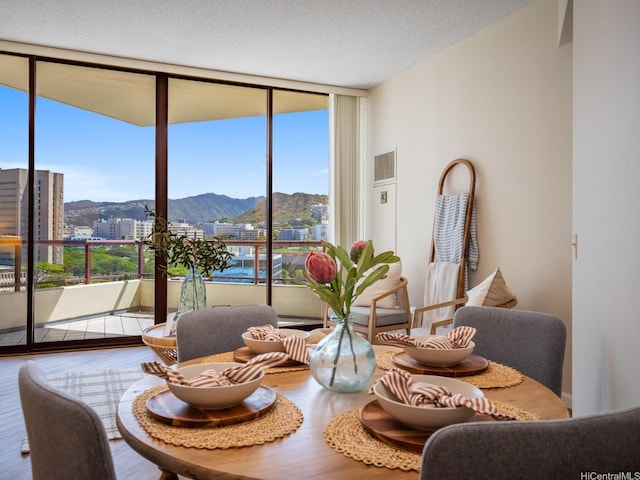 725 Kapiolani Blvd Unit 1105, Honolulu, HI 96813 - dining space with expansive windows, a mountain view, wood finished floors, and a city view