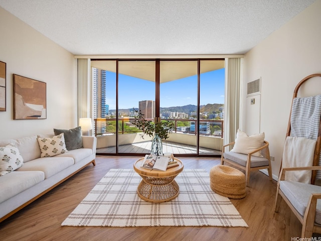 725 Kapiolani Blvd Unit 1105, Honolulu, HI 96813 - living area with floor to ceiling windows, wood finished floors, a textured ceiling, and a city view