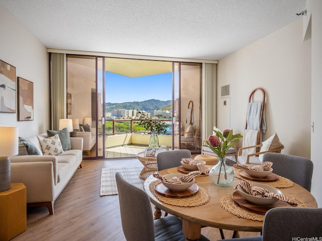 725 Kapiolani Blvd Unit 1105, Honolulu, HI 96813 - dining area with a wall of windows, a mountain view, wood finished floors, a textured ceiling, and a view of city