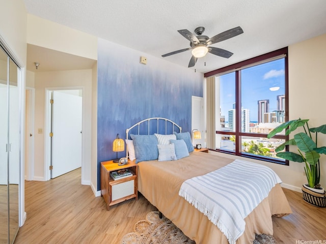 725 Kapiolani Blvd Unit 1105, Honolulu, HI 96813 - bedroom featuring wood finished floors, a closet, a ceiling fan, and a view of city