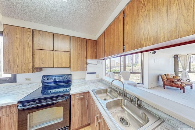 5080 Likini St Unit 518, Honolulu, HI 96818 - kitchen with black range with electric cooktop, light countertops, healthy amount of natural light, and a textured ceiling