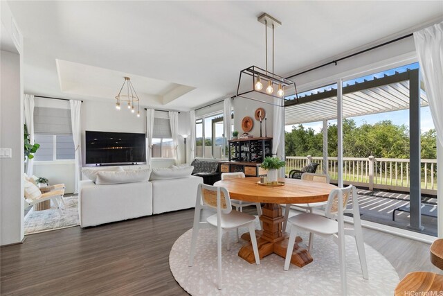 91-1123 Hokua St, Ewa Beach, HI 96706 - dining room featuring dark wood finished floors, a raised ceiling, and a chandelier