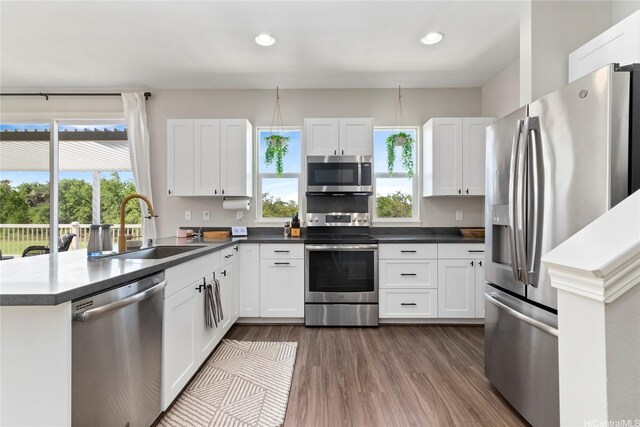 91-1123 Hokua St, Ewa Beach, HI 96706 - kitchen featuring appliances with stainless steel finishes, a sink, dark wood-type flooring, white cabinets, and dark countertops