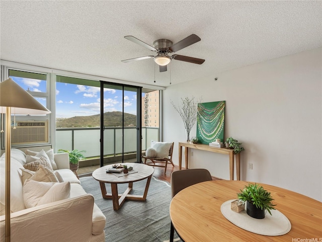 3009 Ala Makahala Pl Unit 1507, Honolulu, HI 96818 - living area featuring a wall of windows, a ceiling fan, a textured ceiling, and cooling unit
