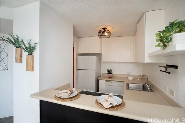 300 Wai Nani Way Unit 1815, Honolulu, HI 96815 - kitchen with white appliances, a sink, a peninsula, white cabinetry, and a textured ceiling