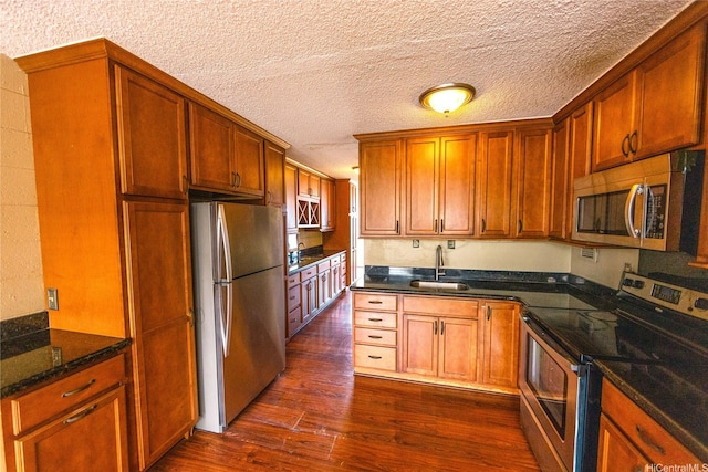 84-965 Farrington Hwy Unit B216, Waianae, HI 96792 - kitchen featuring stainless steel appliances, a sink, dark wood-type flooring, a textured ceiling, and dark stone counters