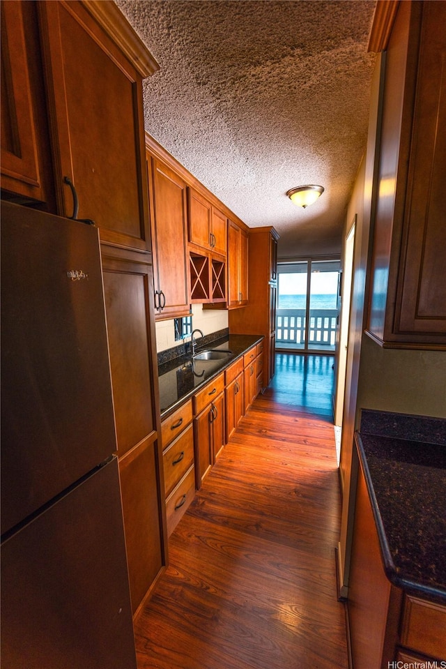 84-965 Farrington Hwy Unit B216, Waianae, HI 96792 - kitchen featuring freestanding refrigerator, dark wood-style floors, a sink, a textured ceiling, and brown cabinets