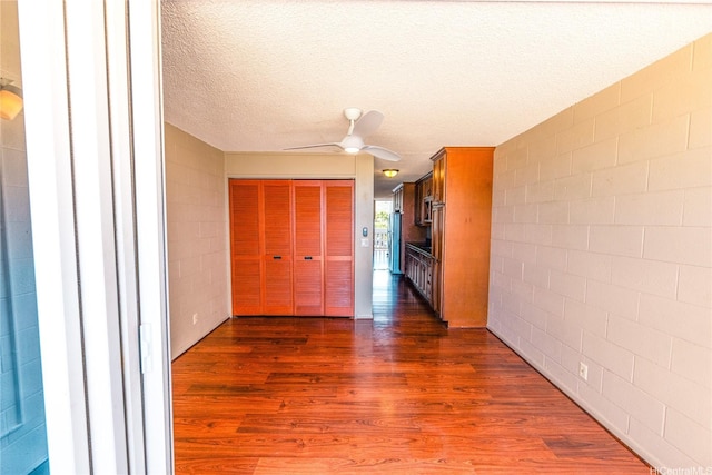 84-965 Farrington Hwy Unit B216, Waianae, HI 96792 - hall featuring dark wood-style flooring, concrete block wall, and a textured ceiling