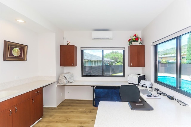 office area with a wall mounted AC, healthy amount of natural light, light wood-type flooring, and recessed lighting