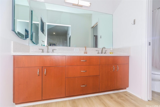 full bathroom featuring double vanity, wood finished floors, and toilet