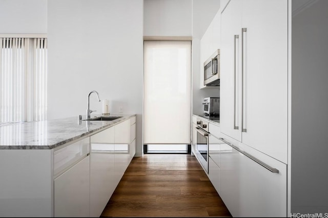 987 Queen St Unit 814, Honolulu, HI 96814 - kitchen with stainless steel appliances, a sink, modern cabinets, a peninsula, and dark wood-style floors