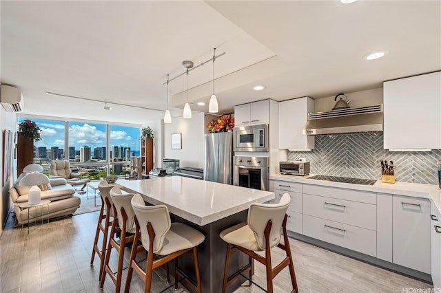 1200 Queen Emma St Unit 3610, Honolulu, HI 96813 - kitchen with appliances with stainless steel finishes, exhaust hood, a wall mounted AC, expansive windows, and open floor plan