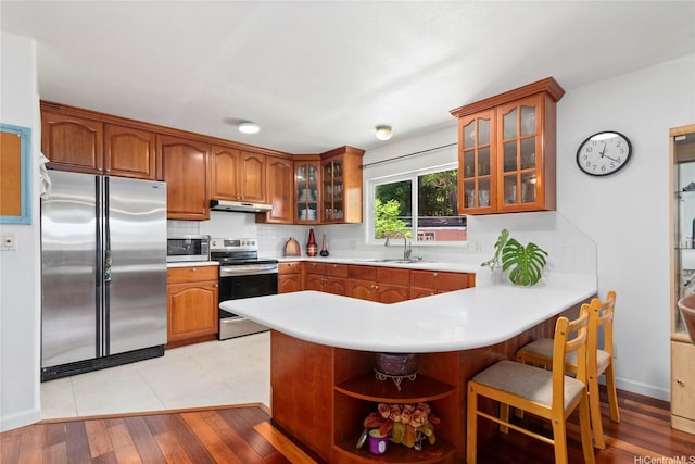 99-060 Nalopaka Pl, Aiea, HI 96701 - kitchen with appliances with stainless steel finishes, a peninsula, under cabinet range hood, and brown cabinets