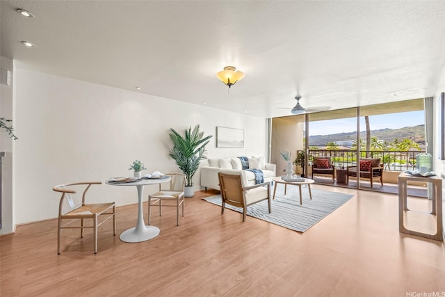 500 Lunalilo Home Rd Unit 22C, Honolulu, HI 96825 - sitting room with wood finished floors, expansive windows, a mountain view, and a ceiling fan