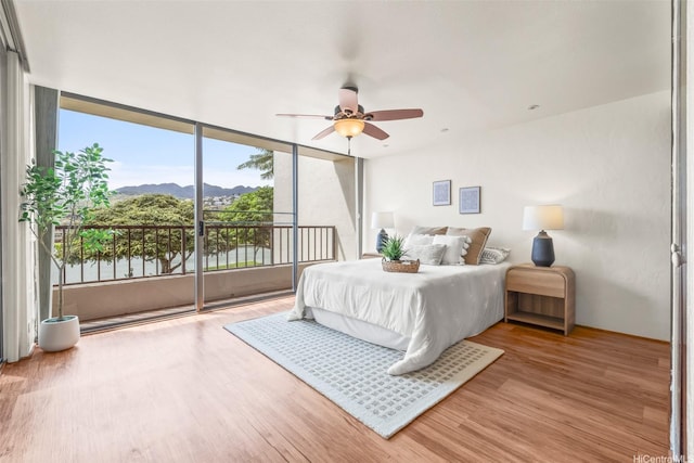 500 Lunalilo Home Rd Unit 22C, Honolulu, HI 96825 - bedroom with a mountain view, access to exterior, wood finished floors, expansive windows, and a ceiling fan