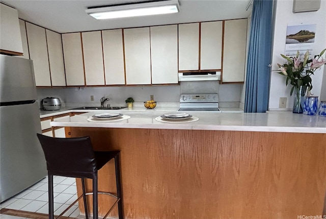 1624 Kanunu St Unit 1208, Honolulu, HI 96814 - kitchen with freestanding refrigerator, stove, under cabinet range hood, a sink, and light countertops