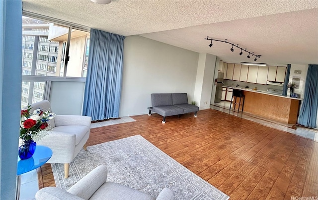 1624 Kanunu St Unit 1208, Honolulu, HI 96814 - living area featuring a textured ceiling, light wood finished floors, and rail lighting