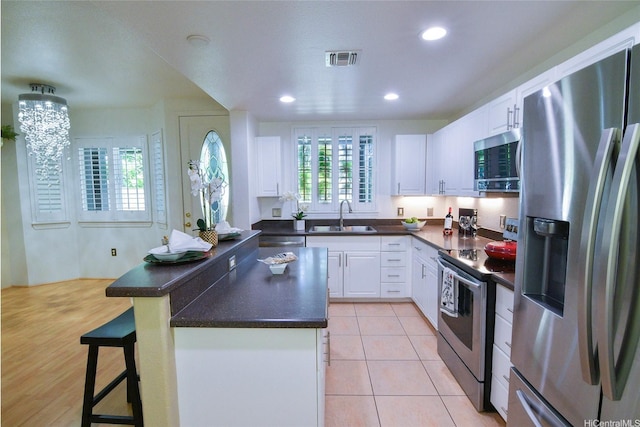7018 Hawaii Kai Dr Unit 6-12, Honolulu, HI 96825 - kitchen featuring appliances with stainless steel finishes, a sink, dark countertops, white cabinets, and recessed lighting
