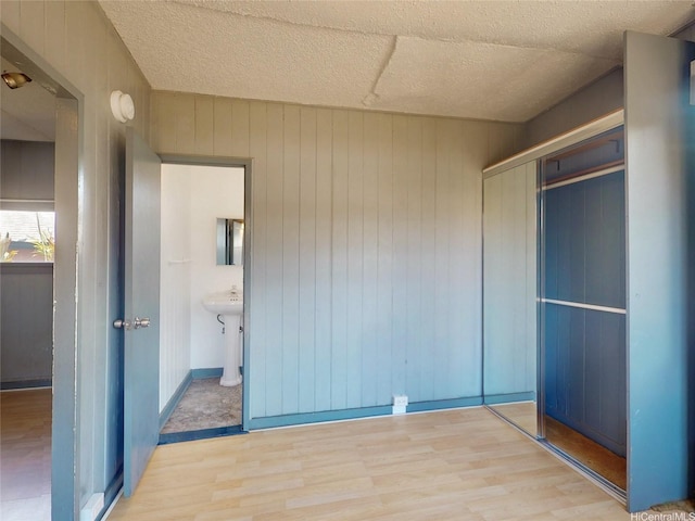 3140 Paliuli St, Honolulu, HI 96816 - unfurnished bedroom with wood finished floors, a closet, a textured ceiling, and wood walls