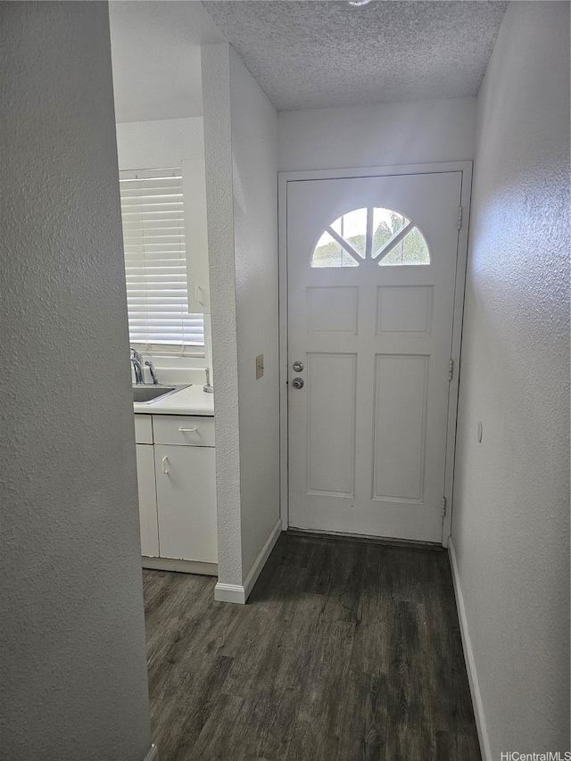 94-209 Paioa Pl Unit L 205, Waipahu, HI 96797 - doorway to outside featuring baseboards, dark wood-style flooring, a textured ceiling, a textured wall, and a sink