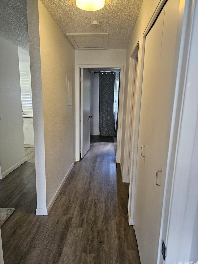 94-209 Paioa Pl Unit L 205, Waipahu, HI 96797 - hall featuring dark wood-style flooring, a textured ceiling, attic access, and baseboards