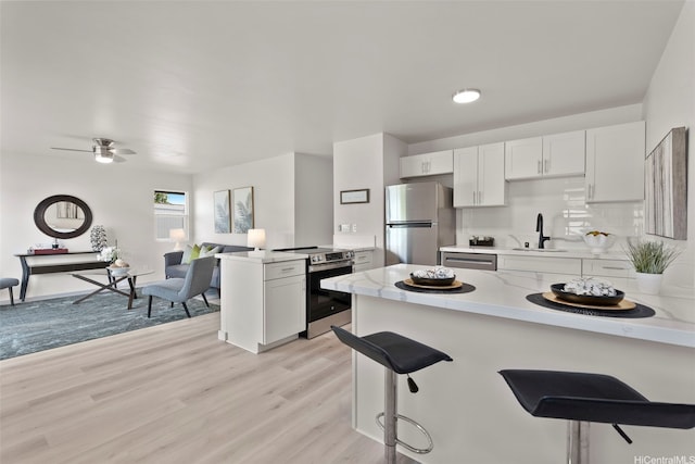 1210 Hooli Cir, Pearl City, HI 96782 - kitchen featuring appliances with stainless steel finishes, a peninsula, a sink, and light wood finished floors