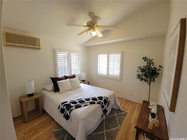91-1565 Wahane St, Kapolei, HI 96707 - bedroom with a wall mounted air conditioner, light wood finished floors, vaulted ceiling, and ceiling fan