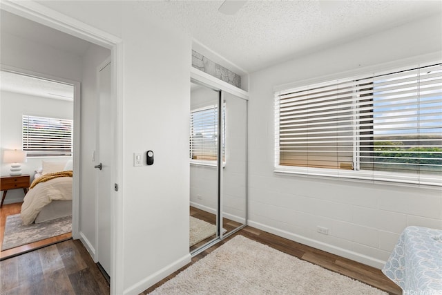 92-1132 Panana St Unit 130, Kapolei, HI 96707 - bedroom featuring baseboards, wood finished floors, a closet, a textured ceiling, and a ceiling fan