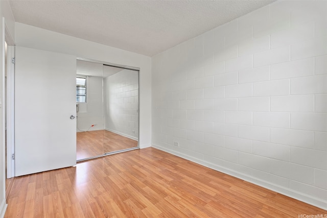 98-1042 Moanalua Rd Unit 2-303, Aiea, HI 96701 - unfurnished bedroom with light wood-style flooring, concrete block wall, and a closet