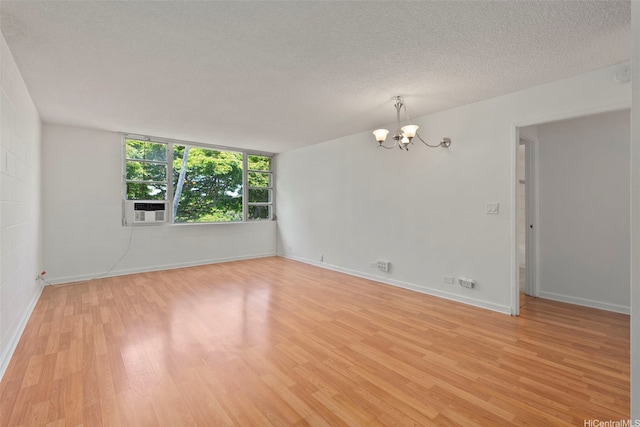 98-1042 Moanalua Rd Unit 2-303, Aiea, HI 96701 - empty room with a chandelier, light wood-type flooring, cooling unit, and a textured ceiling