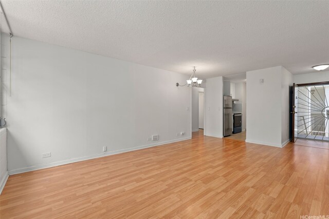 98-1042 Moanalua Rd Unit 2-303, Aiea, HI 96701 - unfurnished living room featuring a chandelier, a textured ceiling, and light wood-type flooring