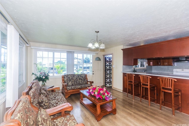 94-1190 Kahuanui St, Waipahu, HI 96797 - living room featuring light wood-style floors, a chandelier, and a textured ceiling