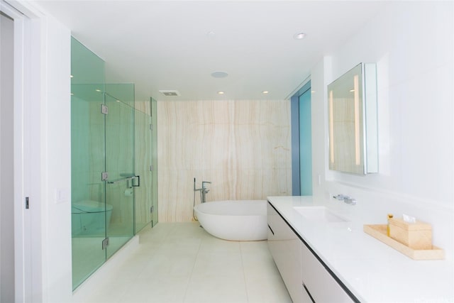 1118 Ala Moana Blvd Unit 2, Honolulu, HI 96814 - bathroom featuring a freestanding tub, vanity, a stall shower, tile patterned flooring, and tile walls