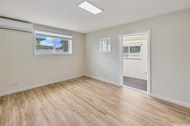 2017 Liliha St, Honolulu, HI 96817 - empty room with a wall mounted AC, light wood finished floors, and baseboards