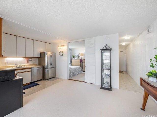 1545 Nehoa St Unit 402, Honolulu, HI 96822 - kitchen featuring stainless steel appliances, light colored carpet, a textured ceiling, light countertops, and white cabinetry