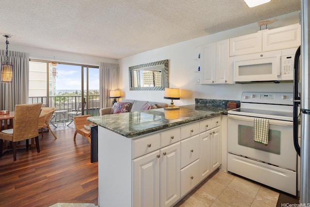 2140 Kuhio Ave Unit 1103, Nuc Honolulu, HI 96815 - kitchen with white appliances, white cabinets, a peninsula, a textured ceiling, and dark stone counters
