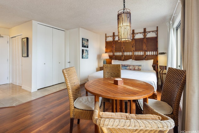 2140 Kuhio Ave Unit 1103, Nuc Honolulu, HI 96815 - dining space featuring light wood-style floors, a textured ceiling, a chandelier, and baseboards