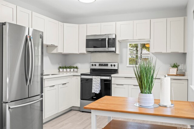 95-1015 Kaapeha St Unit 64, Mililani, HI 96789 - kitchen with appliances with stainless steel finishes, light countertops, and white cabinets