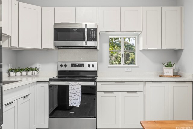 95-1015 Kaapeha St Unit 64, Mililani, HI 96789 - kitchen with appliances with stainless steel finishes, light countertops, and white cabinets
