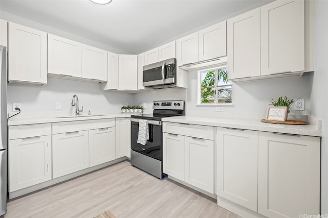 95-1015 Kaapeha St Unit 64, Mililani, HI 96789 - kitchen featuring appliances with stainless steel finishes, a sink, light countertops, and light wood-style flooring