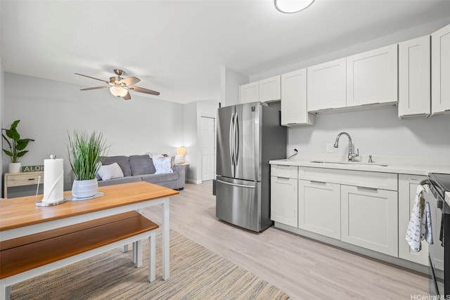 95-1015 Kaapeha St Unit 64, Mililani, HI 96789 - kitchen with freestanding refrigerator, a sink, light countertops, ceiling fan, and white cabinetry