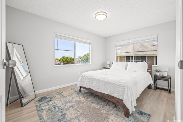95-1015 Kaapeha St Unit 64, Mililani, HI 96789 - bedroom with light wood-style floors, baseboards, and a textured ceiling