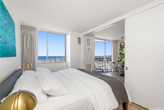 1765 Ala Moana Blvd Unit 990, Honolulu, HI 96815 - bedroom with multiple windows, access to outside, wood finished floors, and a water view