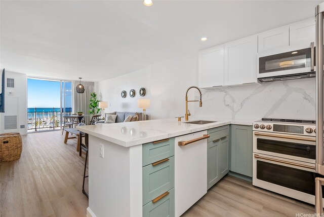 1765 Ala Moana Blvd Unit 990, Honolulu, HI 96815 - kitchen with a sink, double oven range, a wall of windows, a peninsula, and backsplash