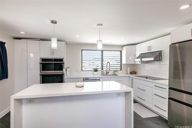 2638 Nakookoo St Unit 501, Honolulu, HI 96826 - kitchen featuring stainless steel appliances, under cabinet range hood, a sink, white cabinets, and a kitchen island