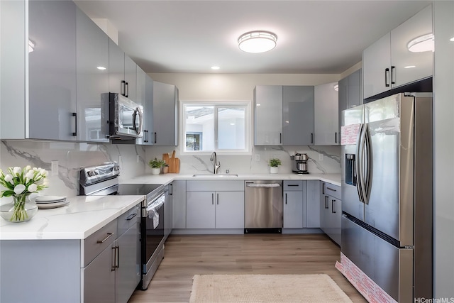 839 Oneawa St, Kailua, HI 96734 - kitchen with appliances with stainless steel finishes, gray cabinetry, a sink, and light wood finished floors