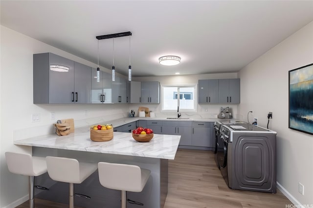 839 Oneawa St, Kailua, HI 96734 - kitchen with a peninsula, gray cabinetry, a sink, and a kitchen bar