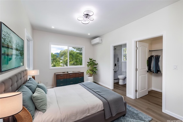 839 Oneawa St, Kailua, HI 96734 - bedroom featuring a spacious closet, wood finished floors, baseboards, a wall unit AC, and ensuite bathroom
